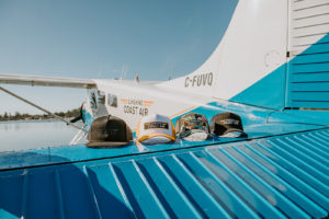 Sunshine Coast Air Trucker Hats on blue airplane wing